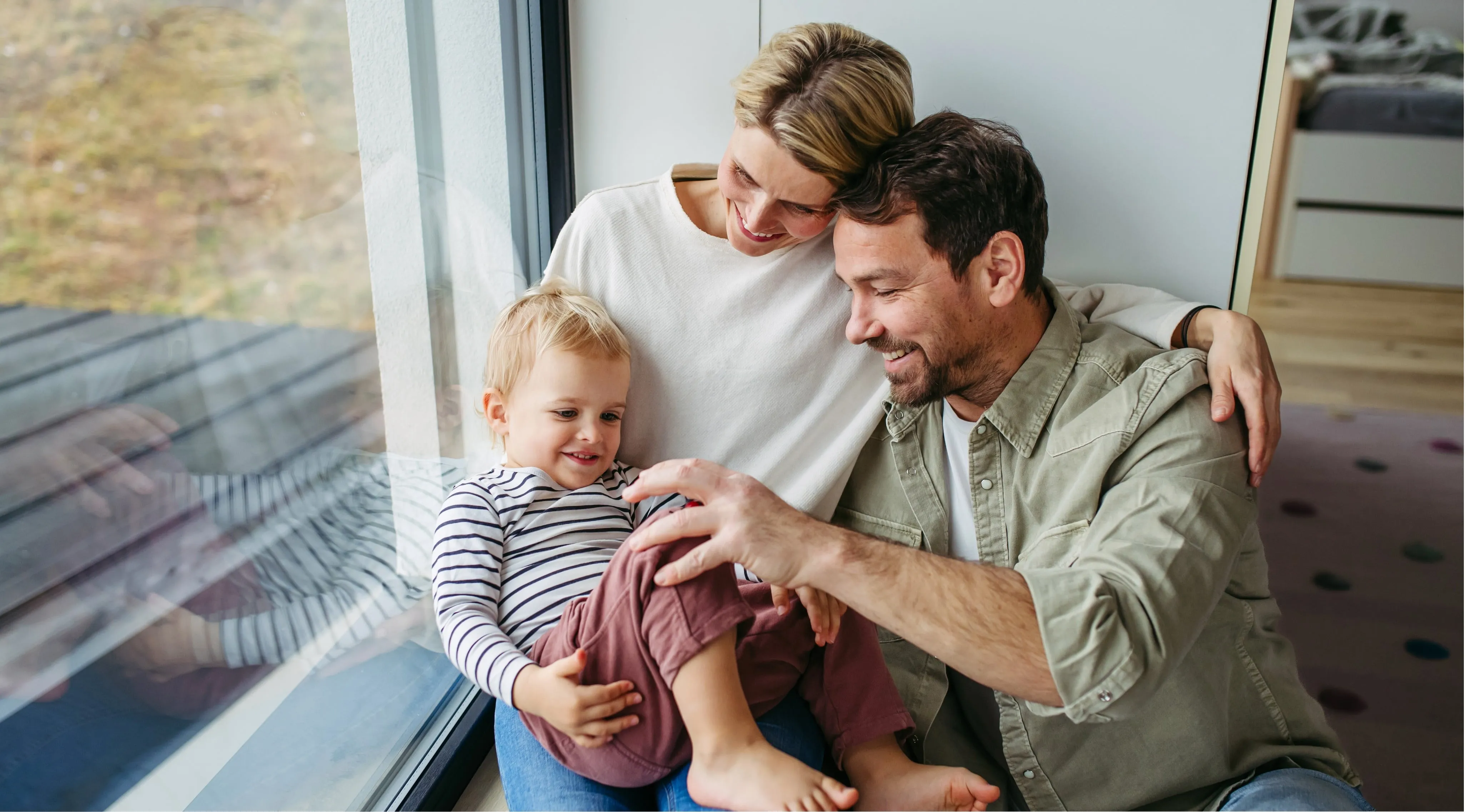 a young family with a child huging and laughing